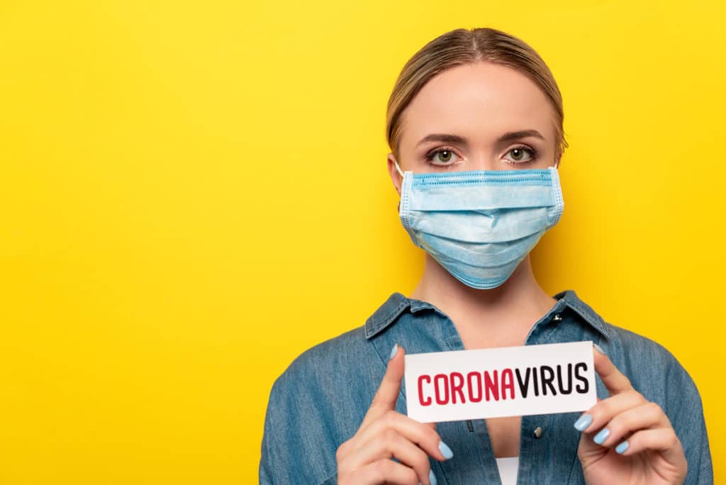 woman in mask with Coronavirus sign